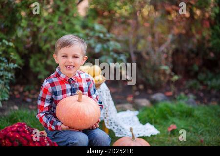 Fröhlicher gemalter Kürbis in den Händen eines Kindes. Halloween-Feier. Kleines Kind bereitet sich auf den Urlaub vor. Stockfoto