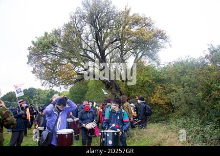 Warwickshire, Großbritannien. Oktober 2020. HS2 Demonstranten brechen durch Barikaden, um auf die Zerstörung eines 250 Jahre alten Baumes aus dem Jahr 2015, des Cubbington Birnenbaums, aufmerksam zu machen 05 Oct 2020. Demonstranten gehen langsam vom Baum weg, singen und spielen Schlagzeug Credit: Denise Laura Baker/Alamy Live News Stockfoto