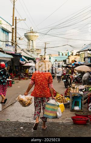 PHU QUOC, VIETNAM - 13. August 2018: Phu Quoc, Vietnam - 2019. August: EINE Frau, die mit ihrem Einkaufen auf dem Duong Dong Morgenmarkt geht Stockfoto