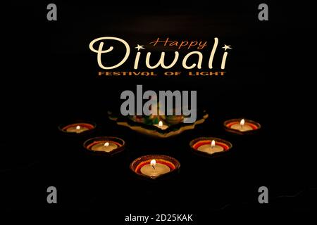 Happy Diwali - Ton Diya Lampen während Dipavali, hinduistischen Festival der Lichter Feier beleuchtet. Bunte traditionelle Öllampe Diya auf dunklem Hintergrund. Kopieren Stockfoto