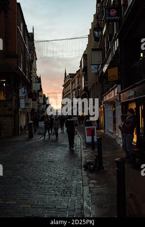 Weihnachtseinkäufer auf den Kopfsteinpflaster der Watergate Street genauso wie die Sonne Sätze Stockfoto