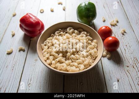 Nahaufnahme der Macaroni-Pasta in einer Schüssel und Gemüse Auf einem Hintergrund Stockfoto