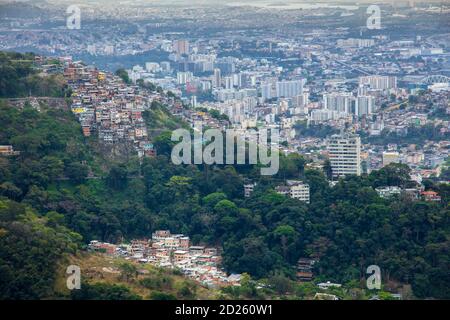 Blick auf die Innenstadt von Rio und eine Favela Slum Gemeinde in der Nachbarschaft von Santa Teresa, Rio de Janeiro, Brasilien Stockfoto