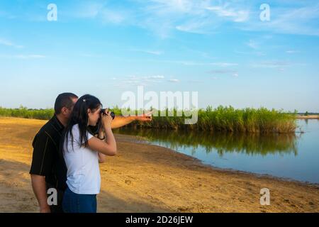 Fotografie Unterricht am Fluss im Sommer. Die Lehrerin zeigt einer Fotografin, wie man Fotos macht. Stockfoto