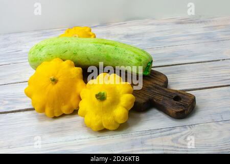 Zucchini und gelbe Mini-Patty Pfanne Squashes auf Holztisch close-up. Gesunde Ernährung Konzept. Stockfoto