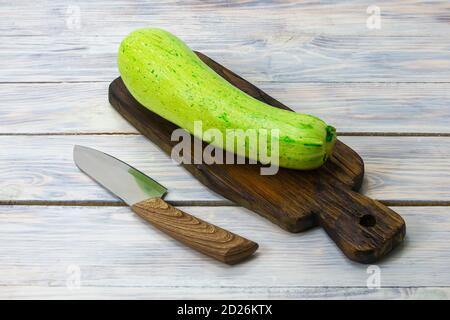 Zucchini auf dunklem Schneidebrett und Messer. Das Konzept der umweltfreundlichen Produkte, Mono-Diät. Stockfoto