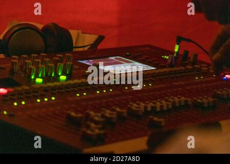 Audio-Sound-Mixer-Bedienfeld. Tasten der Soundkonsole zum Einstellen der Lautstärke. Fotos am späten Abend Stockfoto