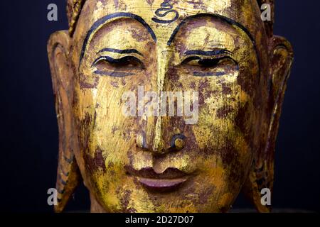 Nahaufnahme von isolierten alten Goldfarbe Holz Buddha Kopf Gesicht der thailändischen Statue im buddhistischen Tempel Stockfoto