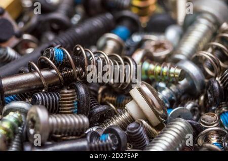 Nägel und Schrauben und Muttern für die Arbeit, Metall-Kleinteile, viele kleine und nicht neue Elemente für die Reparatur, Arbeitshintergrund, Tageslicht Stockfoto