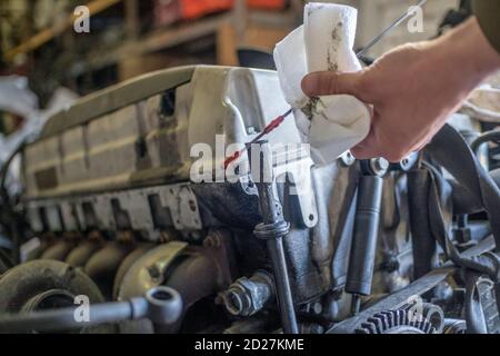 Ein Automechaniker überprüft den Ölstand in einem Automotor während der Routinewartung. Nahaufnahme Stockfoto