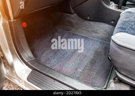 Die Fahrzeugmatte unter dem Beifahrersitz ist hergestellt Aus grauem Textilmaterial im Einsatz nach einer Trockenreinigung Des Fahrgastraums Nahaufnahme duri Stockfoto