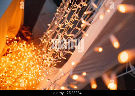 Weihnachten gold Hintergrund. Golden holiday glühende Kulisse. Defokussiertem Hintergrund Mit blinkenden Sternen. Verschwommen Bokeh Vorhang Stockfoto