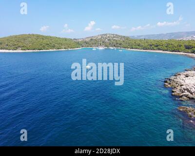 Herrliche, blaue Lagune mit türkisfarbenem Wasser und weißen Felsen, bedeckt mit grünem, dichtem Pinienwald in der Nähe der Stadt Rogoznica, Kroatien Stockfoto
