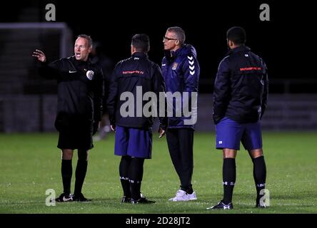 Northampton Town Manager Keith Curle kommt mit Schiedsrichter David Rock für eine Pitch-Inspektion vor dem EFL Trophy Spiel im PTS Academy Stadium, Northampton. Stockfoto