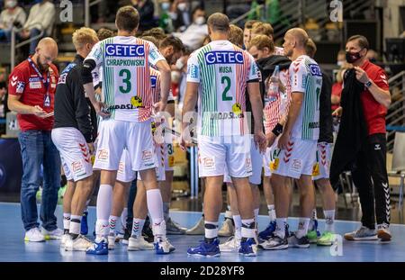 Berlin, Deutschland. Oktober 2020. Handball: Bundesliga, Füchse Berlin - SC Magdeburg, 2. Spieltag, Max-Schmeling-Halle. Trainer Bennett Wiegert (Mitte, meist bedeckt) vom SC Magdeburg steht mit seinem Team während der Auszeit am Rand des Feldes. Quelle: Andreas Gora/dpa/Alamy Live News Stockfoto