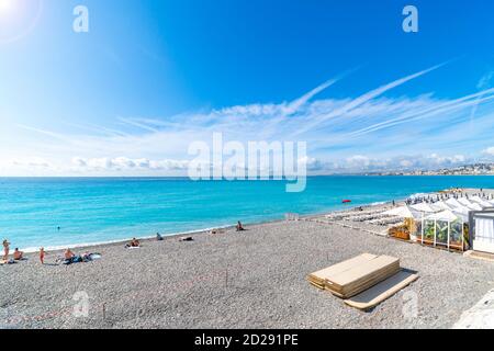 Touristen schwimmen in der Bucht der Engel und entspannen am Mittelmeerstrand in Nizza, Frankreich, an der französischen Riviera. Stockfoto