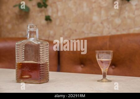 Flasche Cognac, ein Glas auf einem Holztisch Stockfoto