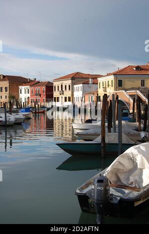 Venedig, Insel Burano, Blick auf einen Kanal am Nachmittag Licht, hell und dunkel Himmel nach einem Sturm, traditionelle venezianische Fassaden Reflexion Stockfoto