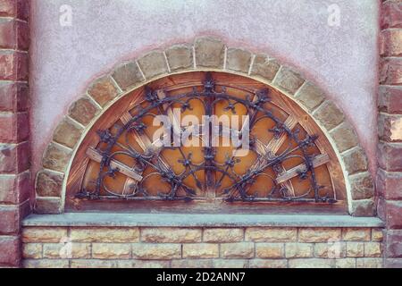 Das alte halbrunde Fenster mit Balken. Holzfenster im Halbkreis. Und gesteinigt. Stockfoto