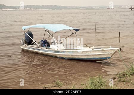 Segeln Motorboot auf schmutzigen Wasser Farbe braun mit grünem Gras Stockfoto