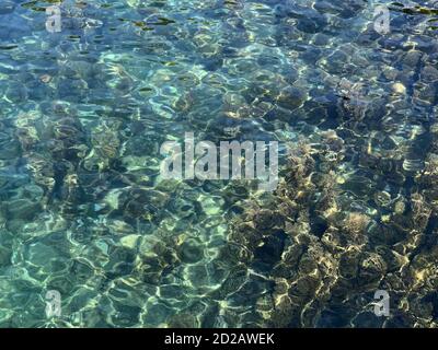 Türkisblaue Farbe kristallklares Wasser, wellige Meeresbrandung, Aquatic Paradies, Mittelmeer Hintergrund Meer, Meer glatte abstrakte Oberfläche im Sommer. Stockfoto