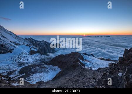 Französische Alpen atemberaubende "über den Wolken" Sonnenuntergang Himmel Landschaft mit einem Bionnassay Gletscher. Mont Blanc bestiegen französische Trekkingroute 'Grand Couloir' Stockfoto