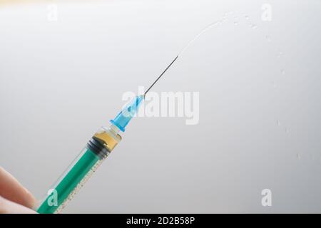 Nahaufnahme einer medizinischen Spritze mit einem Medikament auf einem Weiß-grauer Hintergrund Stockfoto