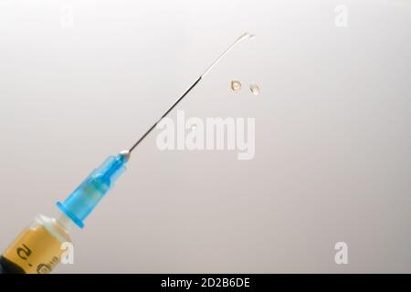 Nahaufnahme einer medizinischen Spritze mit einem Medikament auf einem Weiß-grauer Hintergrund Stockfoto