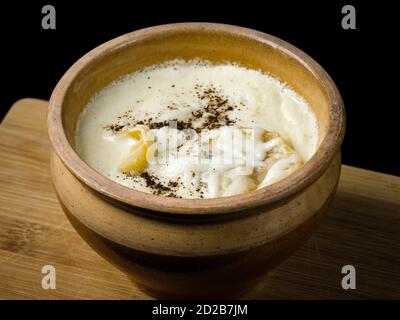 Knödel in einem Topf, in russischer Sprache gekocht, im Ofen.isoliert auf schwarzem Hintergrund. Stockfoto