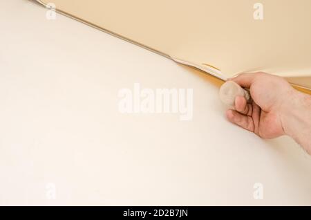 Der Reparaturman macht die Montage der Spanndecke, die Reparatur der Spanndecke wegen des Loches Stockfoto