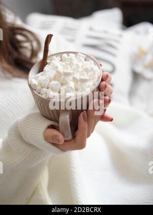 Frauenhände mit Maniküre mit einer Tasse heißer Schokolade und kleinen Marshmallows. Weihnachtszeit. Winter-Heißgetränk-Konzept. Stockfoto