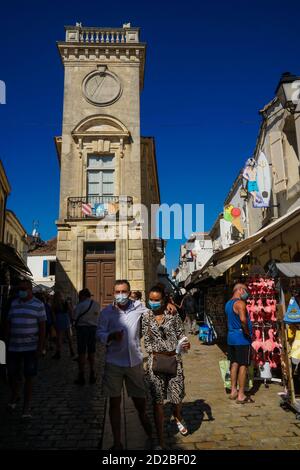 Saintes Maries de la Mer - 09/04/2020: Touristen in einer Straße und im Hintergrund Baroncelli Museum Gebäude Stockfoto