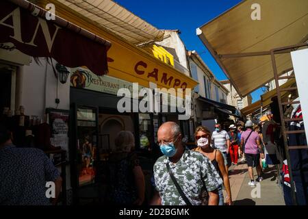 Saintes Maries de la Mer - 09/04/2020: Touristen mit obligatorischer Maske in einer engen Straße Stockfoto