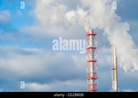 Luftverschmutzung durch Kamine. Fabrikrohre mit Rauch auf einem Hintergrund von grau-blauen Himmel mit Wolken mit einem Ort, um Raum zu kopieren Stockfoto