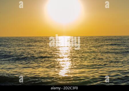 Schöner goldener Sonnenuntergang am Meer. Im Meer bei Sonnenuntergang Segelboote. Stockfoto