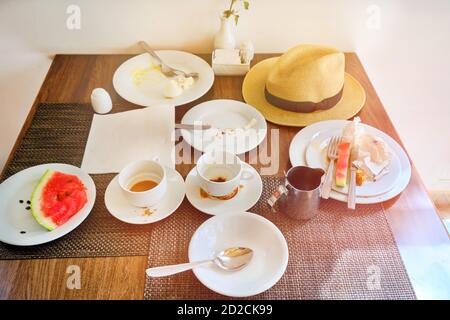 Schmutzige Tassen und Teller auf dem Tisch nach dem Abendessen. Essensreste im Hotel, all inclusive Stockfoto