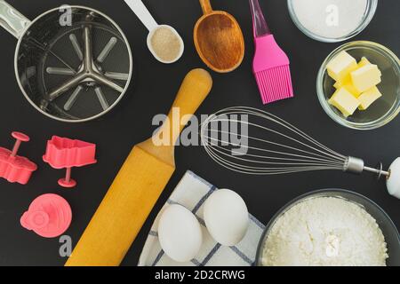 Flach legen Zutaten zum Backen und Küchenutensilien auf ein Schwarzer Hintergrund Stockfoto