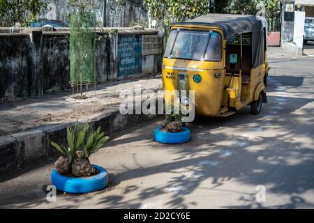 Chennai, Indien - 8. Februar 2020: Eine traditionelle gelbe Auto-Rikscha geparkt auf der Straße neben blauen Zierreifen am 8. Februar 2020 in Chennai Stockfoto