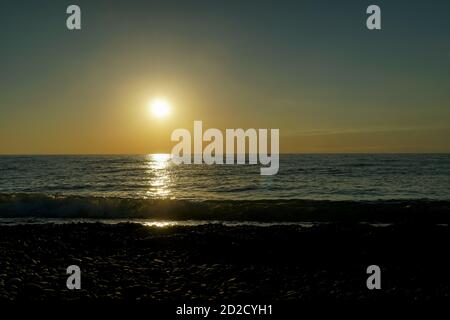 Schöner Sonnenuntergang am Schwarzen Meer in Batumi, Georgien. Blendend orange Sonnenuntergang auf dem schwarzen Meer, geht die Sonne über dem Meer Stockfoto