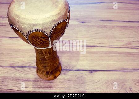Traditionelle tunesische Trommel aus Ton und Kamelhaut. Tontrommel mit Ledermembran auf einem Holztisch, Platz für Text kopieren Stockfoto