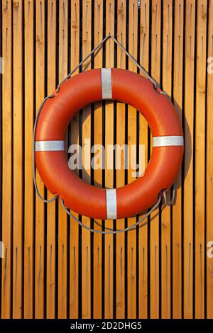 Lifebuoy, die bei Sonnenuntergang an einer hölzernen Dielenwand hängt Stockfoto