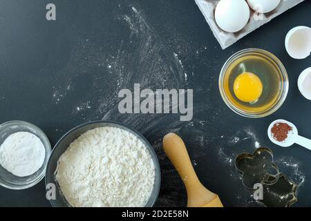 Backzutaten und Backutensilien auf schwarzem Hintergrund Stockfoto