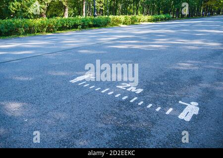 Inschrift auf dem Asphalt, Abstand zu halten. Stockfoto