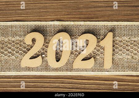 Neujahr 2021. Goldene Zahlen auf einem festlichen Vintage-Band auf einem Holzhintergrund. Weihnachten, Neujahrskomposition mit Platz für Text. Draufsicht. Stockfoto