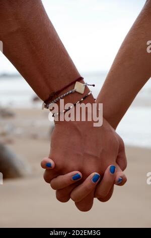 Junges Paar Hand in Hand am Strand Stockfoto