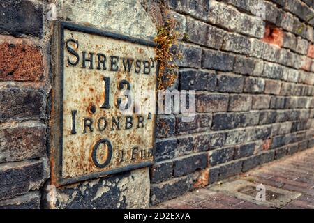 Wegweiser aus Gusseisen in Ironbridge, Shropshire, zeigt 13 Meilen nach Shrewsbury und 1 Furlong nach Ironbridge Stockfoto
