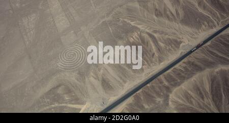 Zwei Lastwagen auf dem Pamamerican oder Inter-American Highway erweitern diese Luftaufnahme des Spiral-Geoglyps in den Nazca Lines, Peru Stockfoto