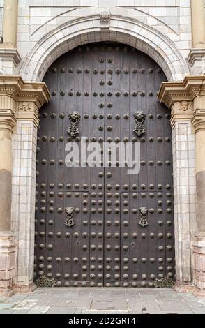 Lima, Peru - 4. Dezember 2008: Basilika Kathedrale St. Johannes der Apostel Haupteingang. Nahaufnahme von kleineren braunen Türsatz mit Säulen unter Bogen auf Stockfoto