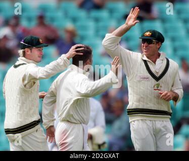 Matthew Hayden von Australia (R) ist zusammen mit Teamkollege Michael Clarke (L) wie sie Stuart MacGill (C) gratulieren, der World XI hatte Andrew Flintoff gefangen für 15 am Tag vier der Grille Super Test in Sydney 17. Oktober 2005 läuft. Die Weltauswahl kämpften, um eine massive Niederlage im super-Test gegen Australien zu vermeiden, nach dem Verlust von drei schnelle Pforten am vierten Tag auf Monday.REUTERS/Will Burgess