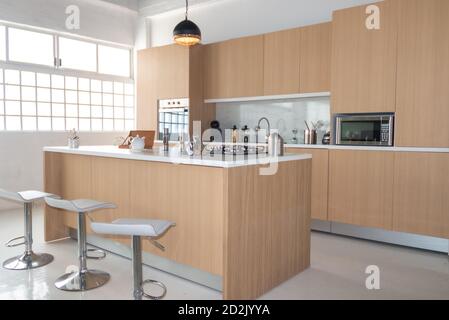 Moderne Küche in Beige und Weiß. Esszimmer aus Holz für 6 Personen mit grauen Stühlen. Innenarchitektur Stockfoto